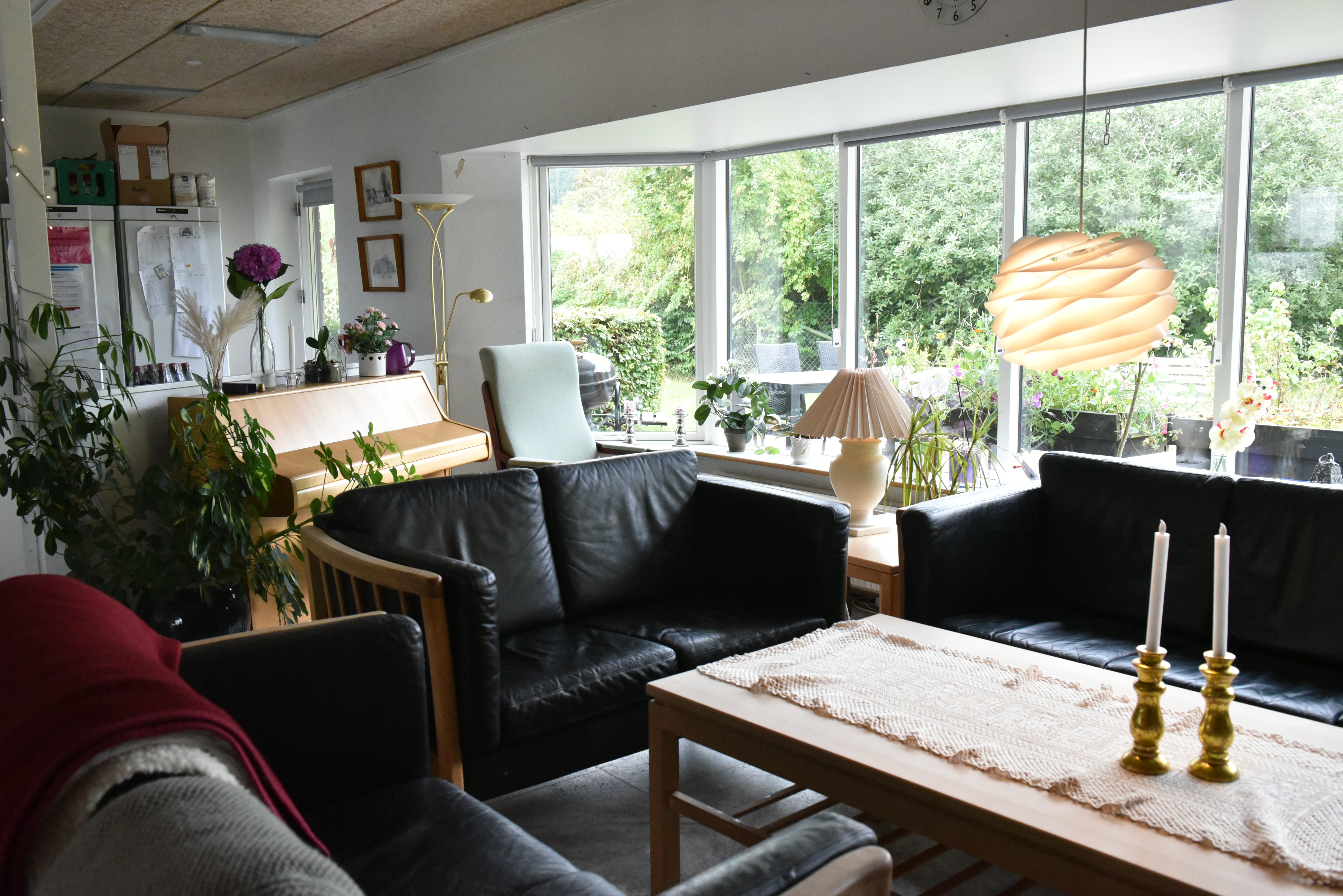 Stue med klaver og sofaarrangement hos Kildevang