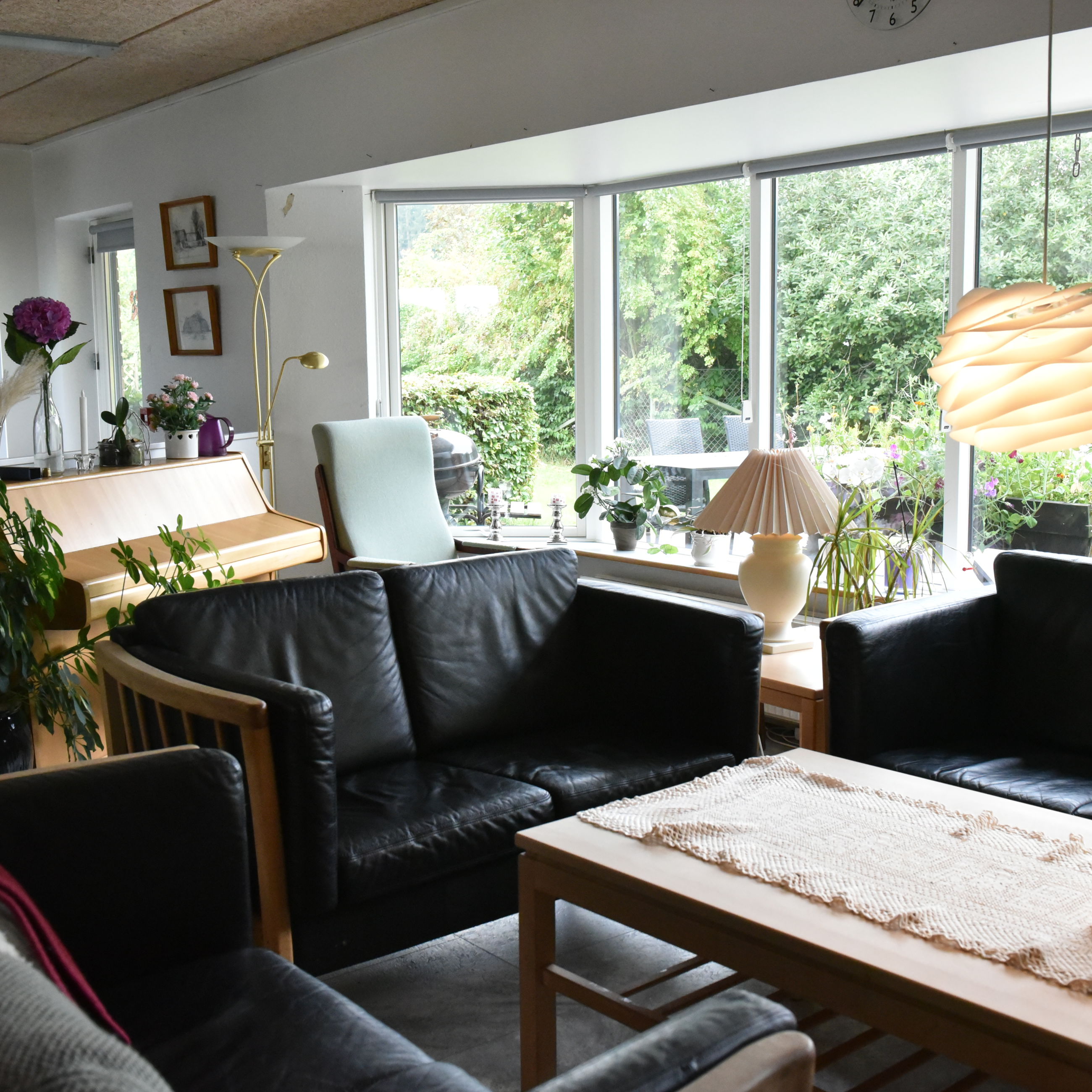 Stue med klaver og sofaarrangement hos Kildevang