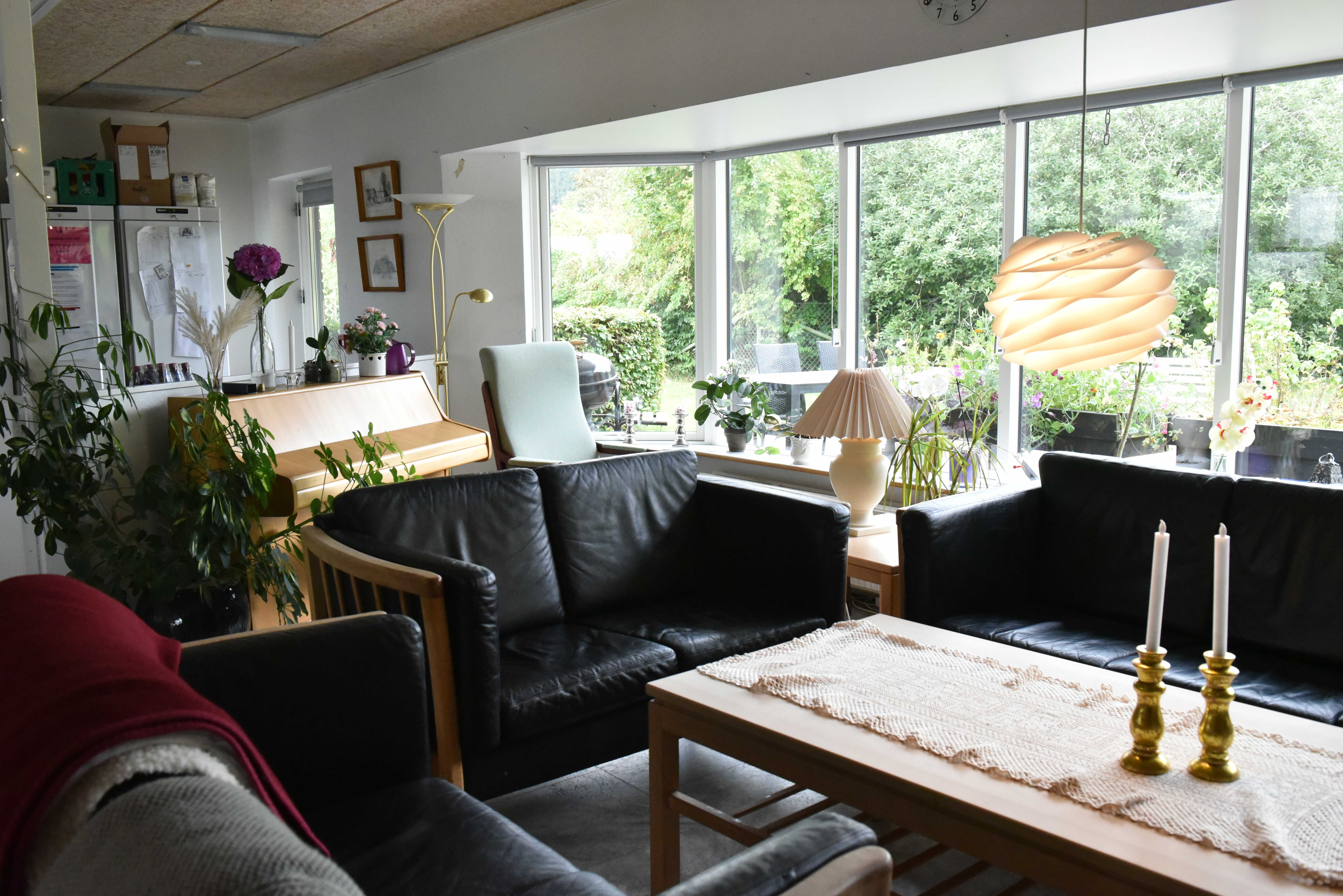 Stue med klaver og sofaarrangement hos Kildevang