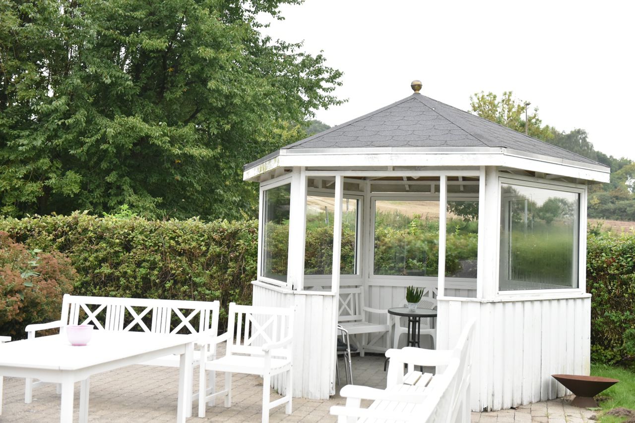 Terrasse og hvid træpavillon hos Kildevang