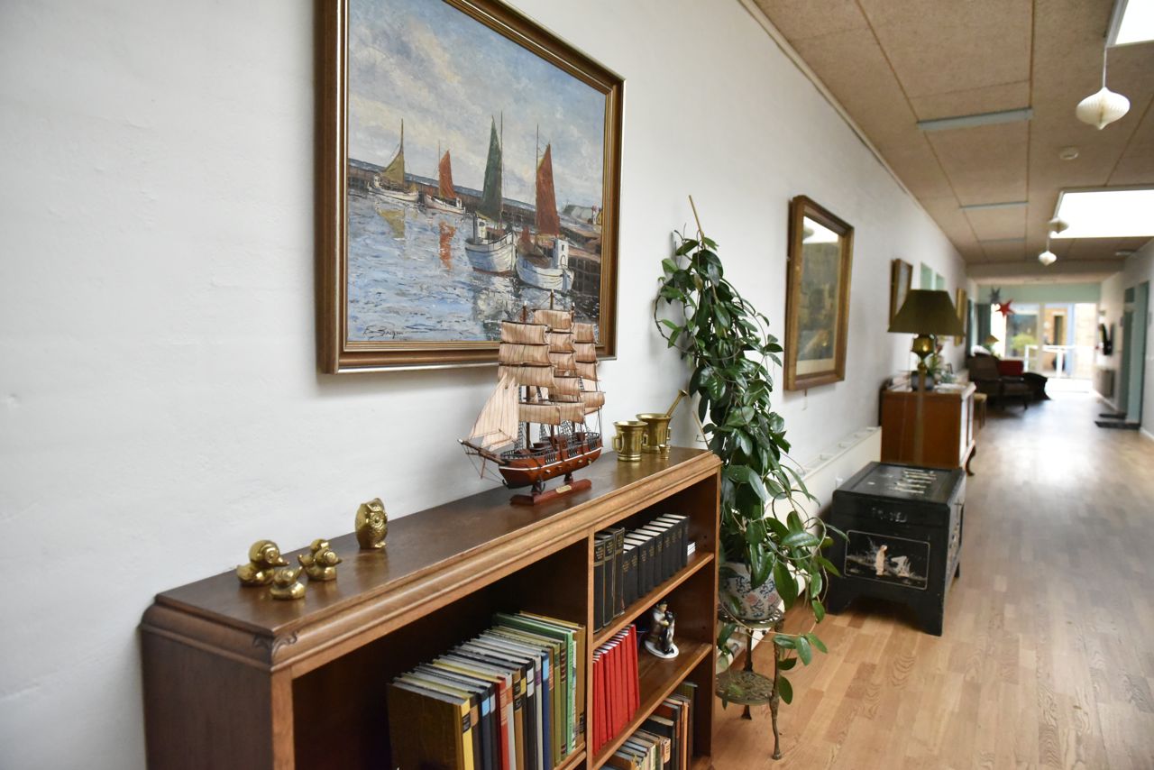Gang med bogreol og malerier