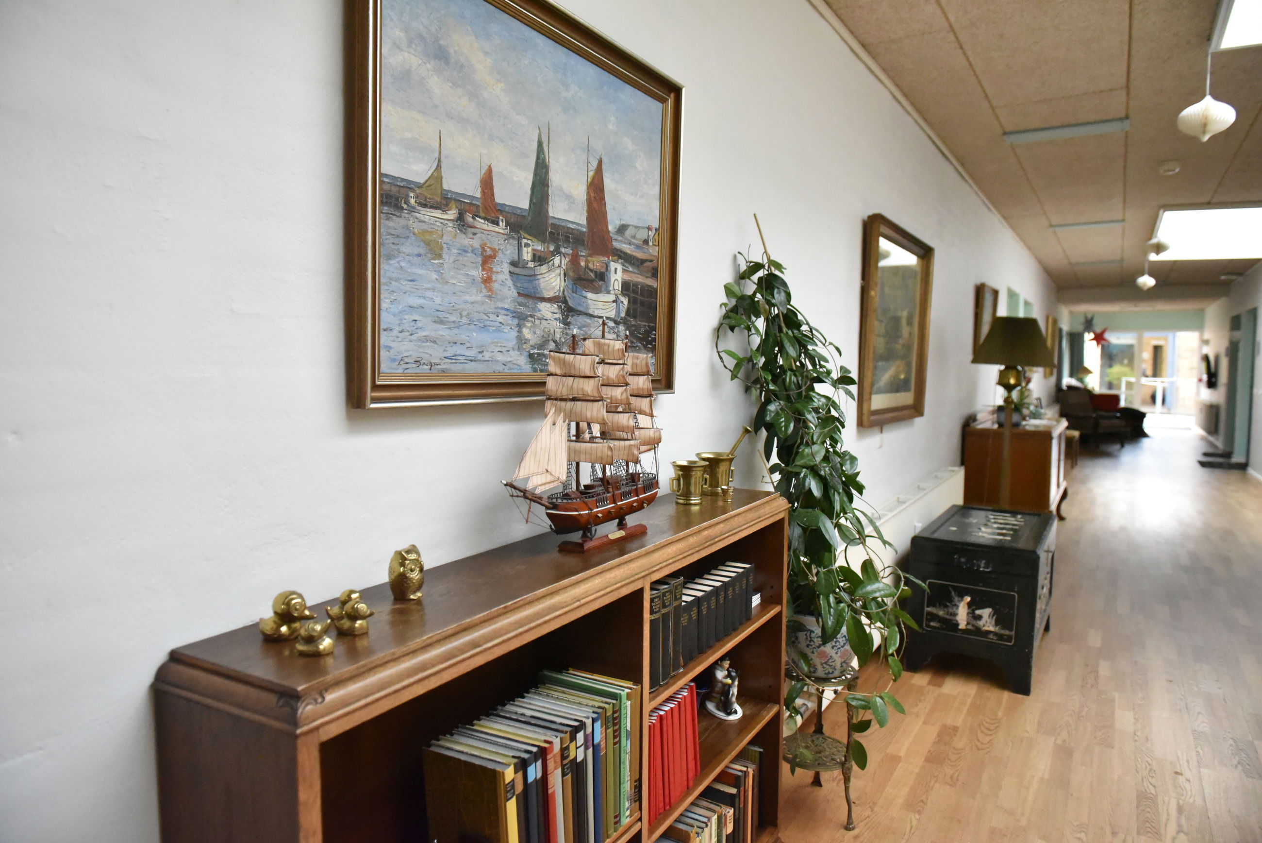 Gang med bogreol og malerier