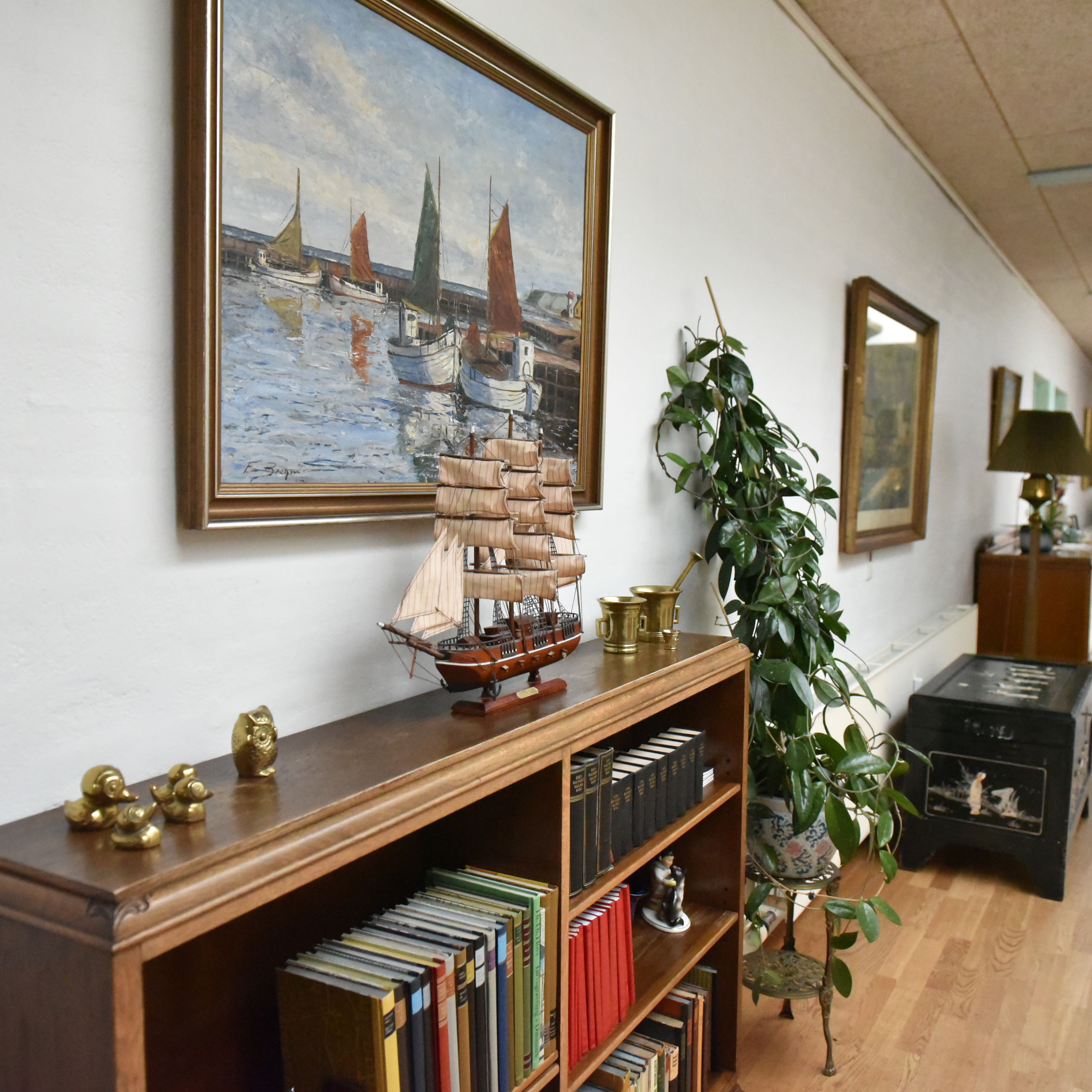 Gang med bogreol og malerier